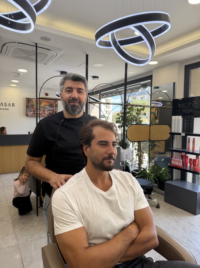 Hikmet Yaşar ve memnun misafiri berber koltuğunda