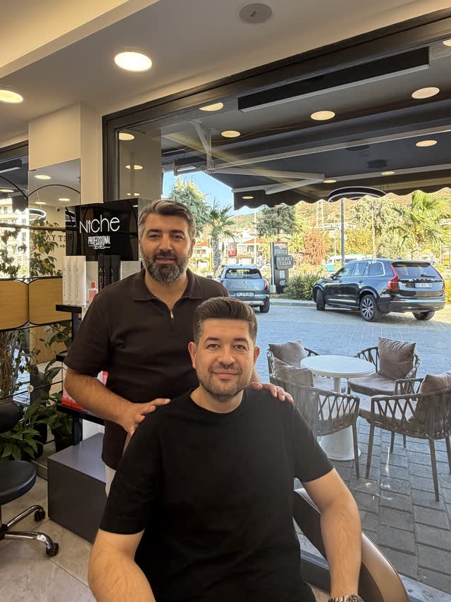 Hikmet Yaşar ve misafiri salonun vitrin önünde